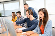 © W PRODUCTION - group of young people with desktop computer in row and headset training with teacher instructor in customer service call support helpline business center