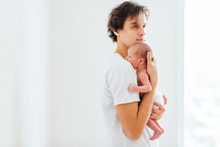 Happy Father Hugging And Holding Newborn Baby On White Background.
