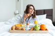© Drobot Dean - Portrait of a pretty happy woman having breakfast in bed
