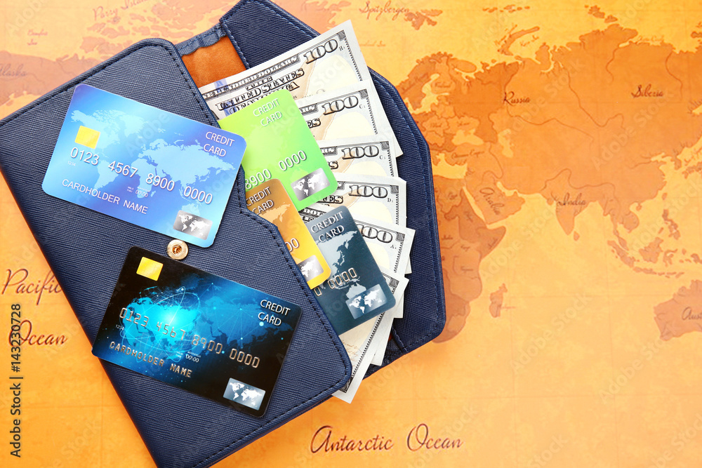 Credit cards with money in wallet on  world map background