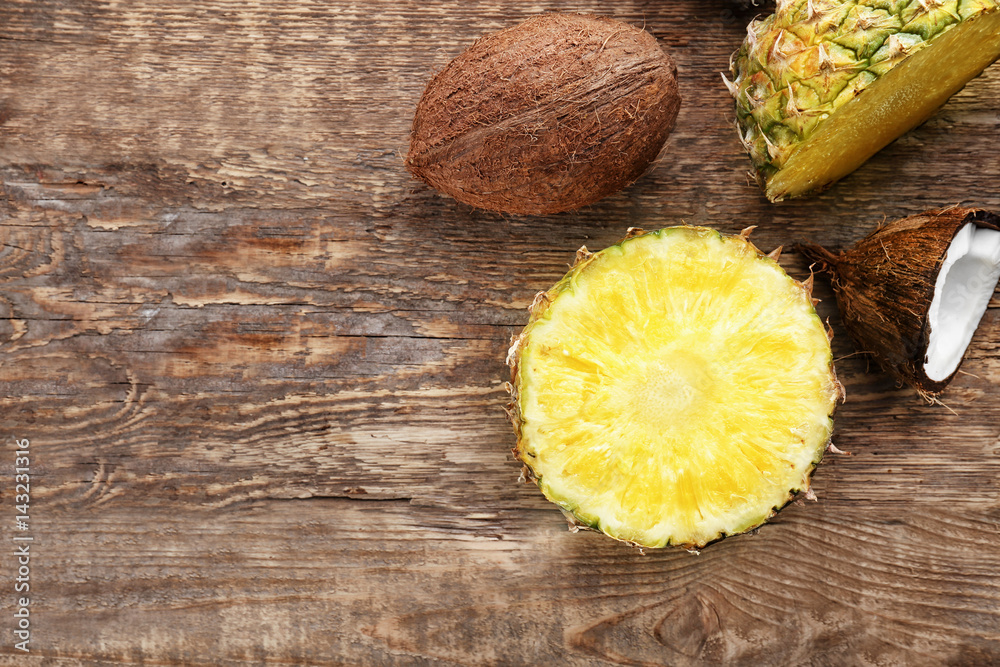 Fresh pineapple and coconuts on wooden background