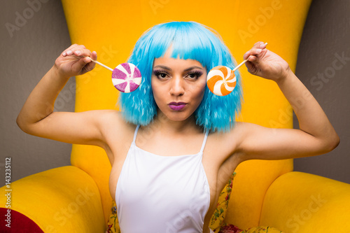 Fotografie, Obraz Mixed race girl in whimsical candy fashion on giant armchair