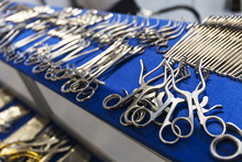 Surgical Instruments And Tools Including Scalpels, Forceps And Tweezers Arranged On A Table For A Surgery