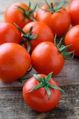 Tomatoes on a wooden background. Fresh juicy tomatoes on an old wooden table. 