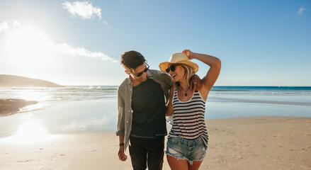 Couple walking on seashore and laughing