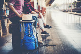 Fototapeta  - Young tourist couple with backpack sitting on bench at the train station. Two young tourist are waiting to get on the train and begin their journey. Travel concept.