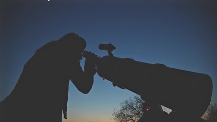 Wall Mural - girl looking at the sky through a telescope.