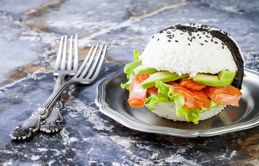 Wall Mural - Homemade asian style gluten free sushi salmon burger. Sushi-food hybrids trend. Bright blue background with copy space