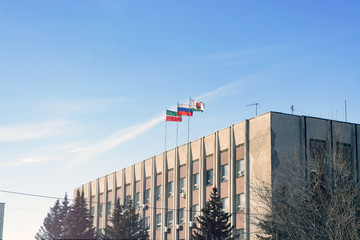 Waving national flag of russian federation on top building against bright blue sky