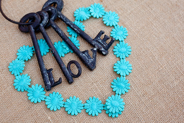 Wall Mural - daisy chain heart on burlap hessian background with metal keys of love
