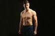 © Africa Studio - Young handsome sportsman on dark background
