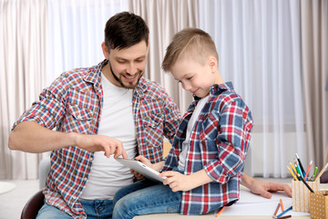 Wall Mural - Father and his son with tablet computer at home