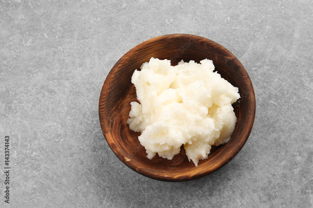 Wooden bowl with fresh coconut oil on table