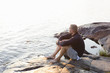 © FOLIO - Sweden, Stockholm Archipelago, Sodermanland, Orno, Mature man sitting on rocky lakeshore