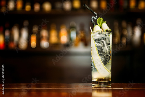 Cuadros en Lienzo Cocktail with cucumber on a bar counter in a night club