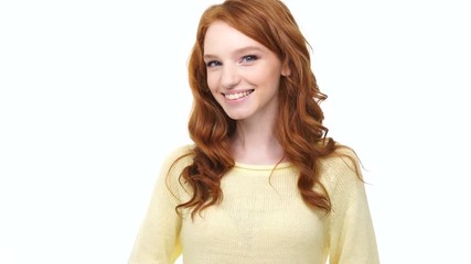 Wall Mural - Happy positive smiling young redhead woman with thumbs up gesture over white background