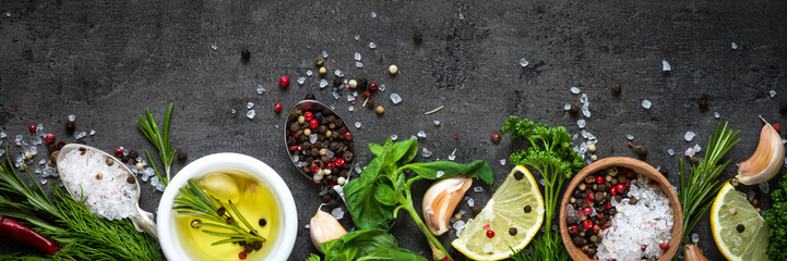 Wall Mural - Selection of spices herbs and greens. Top view black background. Long banner format