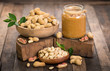 Peanut butter and peanuts on the wooden table