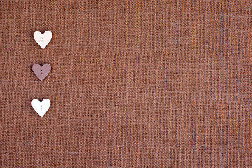 Wall Mural - background - brown color burlap hessian with heart shape buttons
