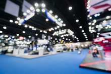 Blurred, Defocused Background Of Public Event Exhibition Hall Showing Cars And Automobiles, Business Commercial Event Concept