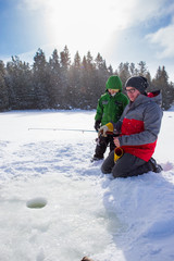 Mixed race family ice fishing