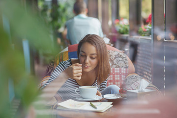 Wall Mural - Young woman sitting indoor in urban cafe