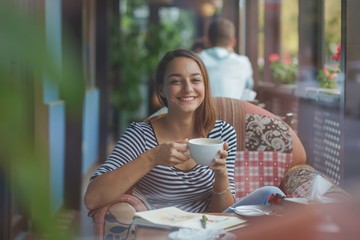 Young woman sitting indoor in urban cafe