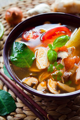 Wall Mural - Asian Vegetarian Vegan soup with tofu, lime, galangal, chili, tomato, shiitake mushrooms, basil and coriander leaves.