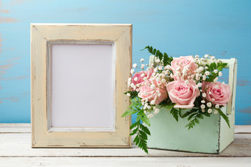 Poster mock up template with rose flower bouquet in box over wooden background