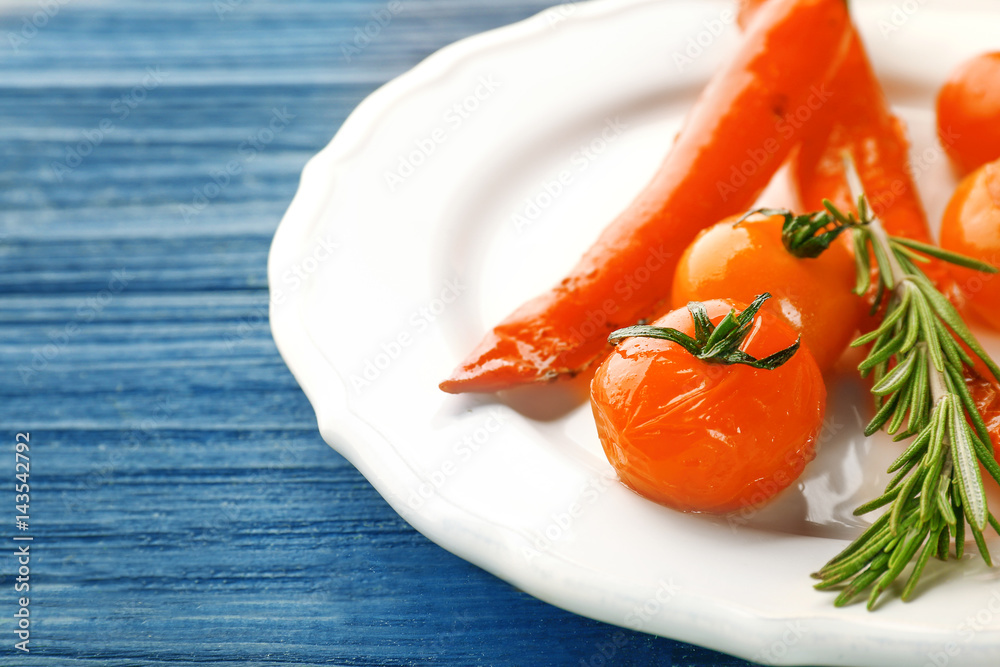 Plate with baked chili pepper and tomatoes on wooden table