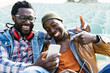 © santypan - Two black race friends having fun with mobile.