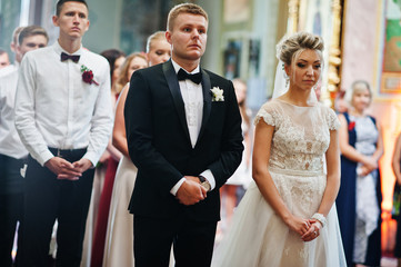 Stylish wedding couple with bridesmaids and best mans at church.