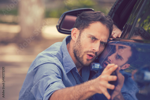 Fotografie, Obraz Worried funny looking man obsessing about cleanliness of his new car