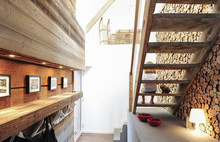 Wooden Staircase, Little Girl And Logs For The Fireplace In An Old Renovated Chalet