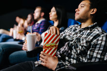 Mixed Race Man Watching A Movie Eating Popcorn