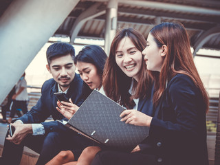 Group of office workers  colleagues discussing and sitting outside office. Business and lifestyle concept.