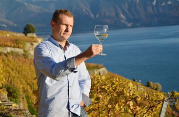 Wall Mural - Man holding a glass of wine. Lavaux, Switzerland