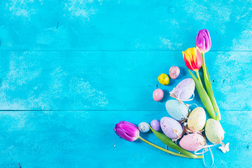  Easter eggs and tulips on bright blue background with copy space