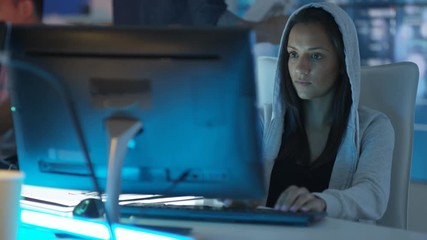  Young creative computer game designer working with colleagues in dark office. 