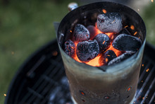 BBQ Grill Pit Glowing And Flaming Hot Charcoal Briquettes Coal Food Background Or Texture Close-Up Top View