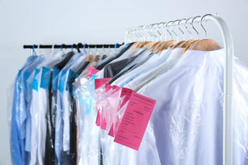 Rack of clean clothes hanging on hangers at dry-cleaning