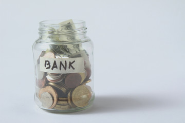 Money jar with coins on wood table