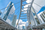 Fototapeta Londyn -  View of high buildings and public sky walk for transit between Sky Transit and Bus Rapid Transit Systems at Sathorn-Narathiwas junction at evening 