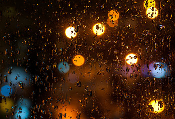 Glass with rain drop background with bokeh in night