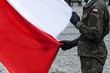 Polish national flag held by a soldier during a ceremony