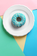 Wall Mural - Plate with tasty glazed donut on colorful background