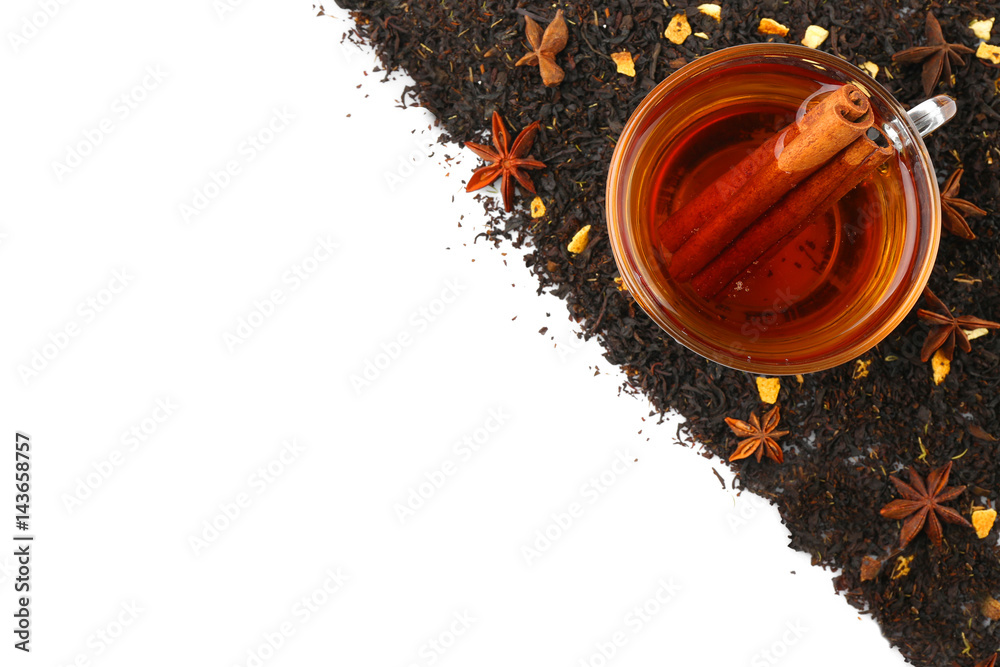 Dried tea leaves and cup of aromatic drink on white background