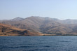 Ein schöner Nachmittag auf dem Van Gölü See in Kurdistan, Anatolien, Türkei, mit ausgewaschenen erodierten Bergen im Hintergrund