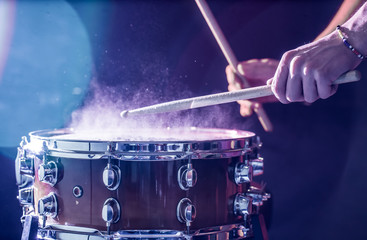 Wall Mural - man plays musical percussion instrument with sticks, a musical concept, beautiful lighting on the stage