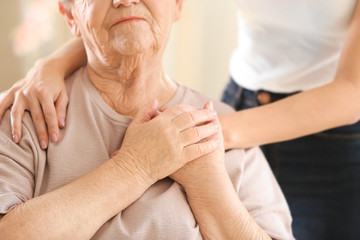 Young girl hugging old woman, closeup